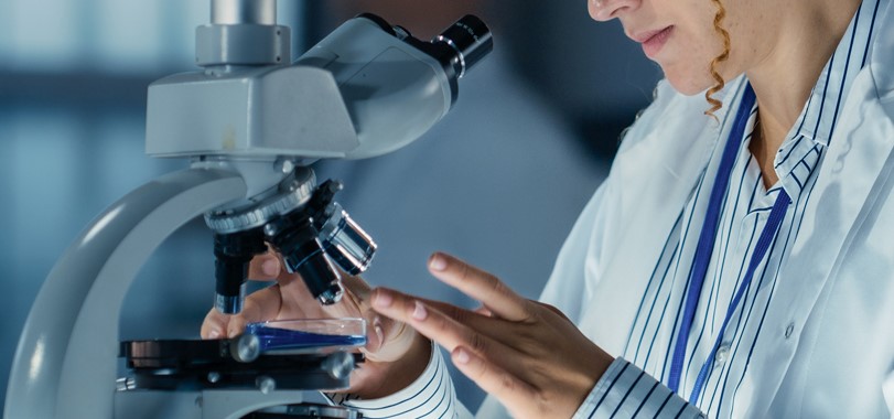 Immagine di una ricercatrice al microscopio